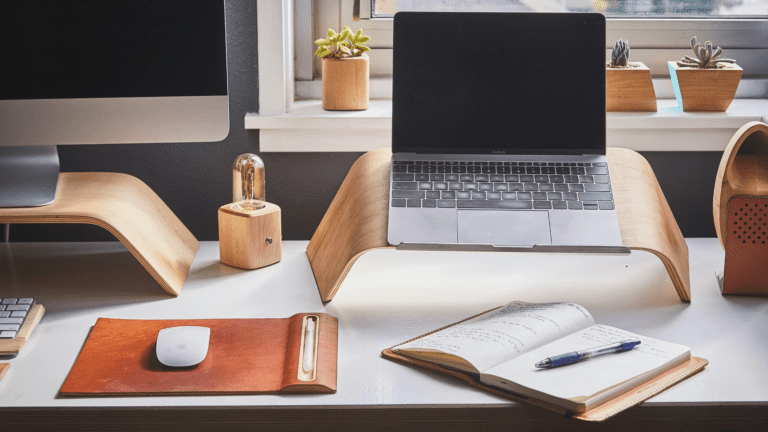 A writer's desk with a notebook and laptop, surrounded by a calm, organized environment, symbolizing a productive writing routine.