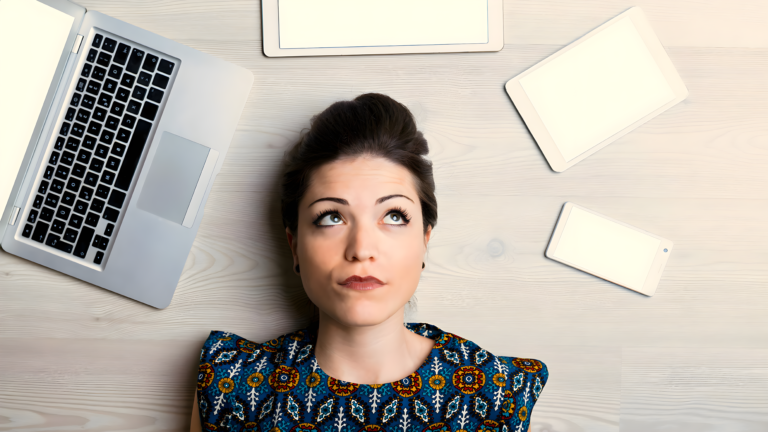 A woman's head surrounded my various electronic devices symbolizing distractions and the need to use writing productivity apps